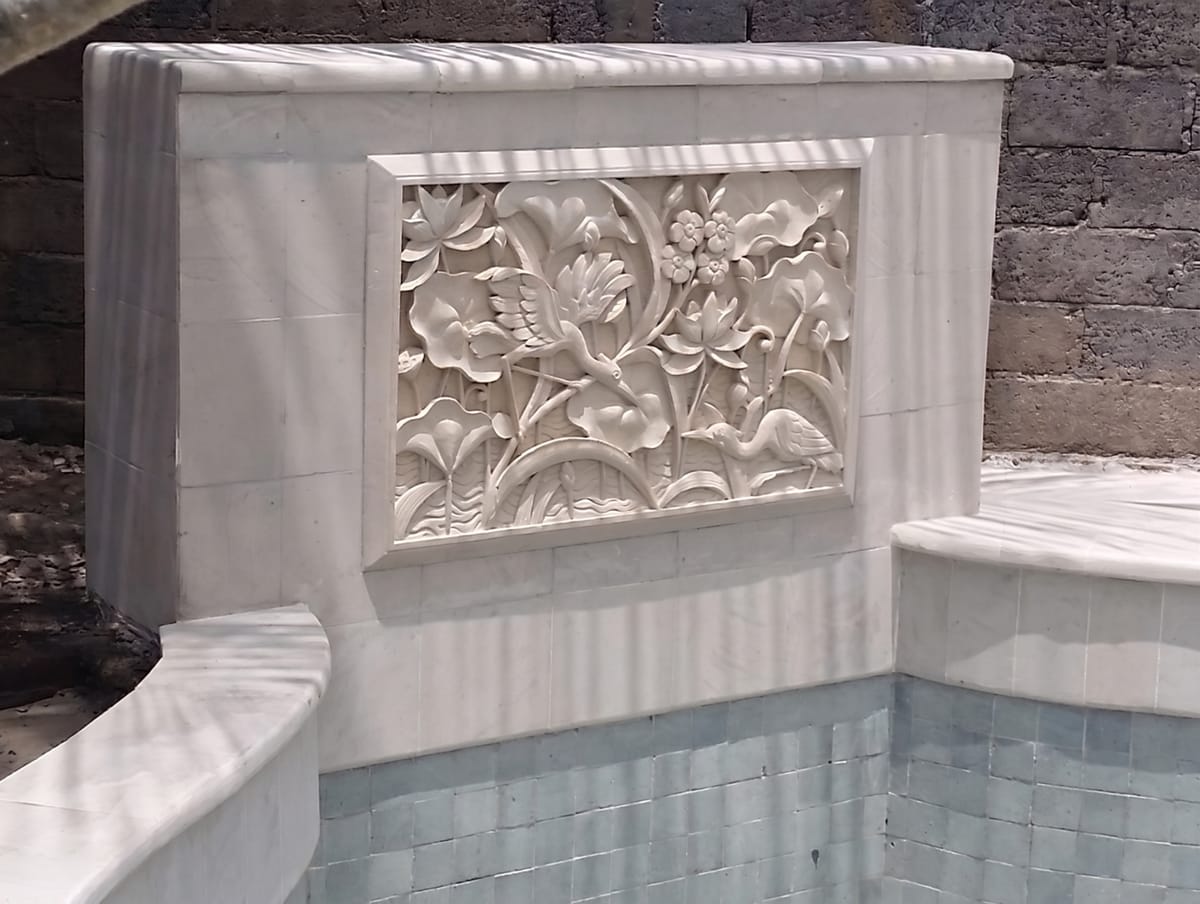 Sheer-descent water feature spilling into a pool in Bali